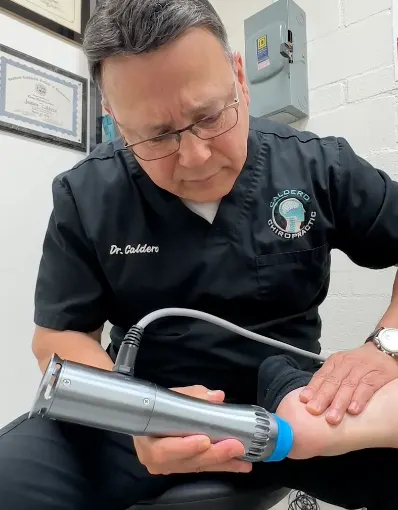 Dr. Caldero performing shockwave therapy on a patient